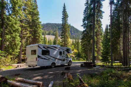 beautiful-campsite-mountains-with-rv-wooden-bench