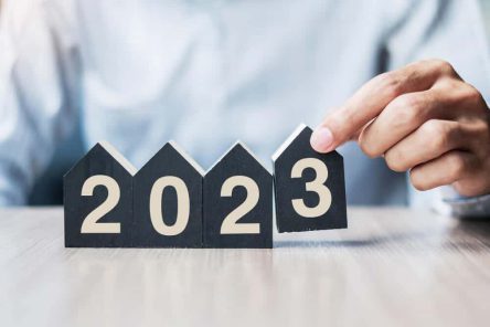 businessman-hands-holding-2023-happy-new-year-with-house-model-table-office-new-house-financial-property-insurance-real-estate-savings-new-year-resolution-concepts (1)